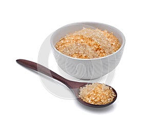 Brown cane sugar in wooden spoonn and white cup isolated