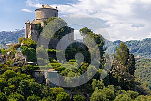 Brown Castle surrounded by green olive trees and plants in the middle of the summer.