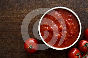 Brown ceramic bowl of chopped tinned tomatoes.