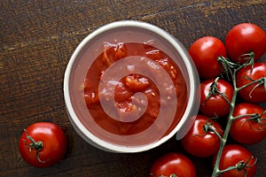Brown ceramic bowl of chopped tinned tomatoes.