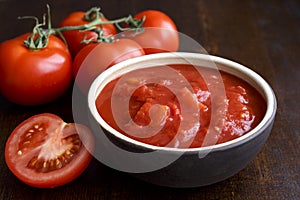 Brown ceramic bowl of chopped tinned tomatoes.