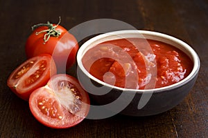 Brown ceramic bowl of chopped tinned tomatoes. photo