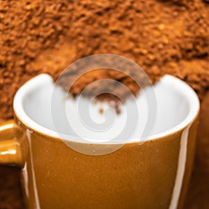 Brown ceramic coffee cup with ground coffee inside closeup, blurred background - Image