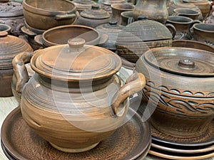 Brown ceramic dishes in a shop window. Clay pots, plates and handmade cups