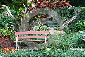 Brown chair in a flowers garden with walkway