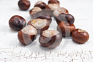 Brown chestnuts on wooden background