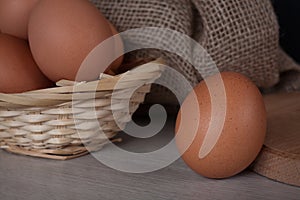 Brown chicken egg close up, fresh eggs in a wicker basket