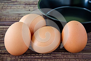 Brown chicken egg and iron pan on the table.