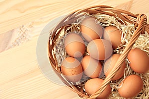 Brown chicken eggs in a basket on a wooden table