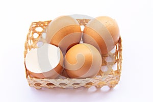 Brown chicken eggs are placed in bamboo trays. With an eggshell on a white background