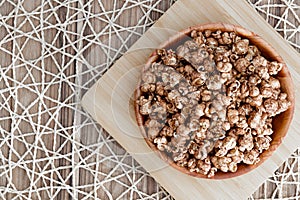 Brown chocolate flawored popcorn on the wood plate