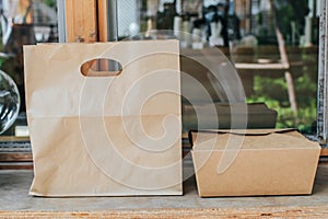 Brown clear empty blank craft paper bag and Kraft corrugated cardboard box with handle for takeaway.Packaging template mock up. De