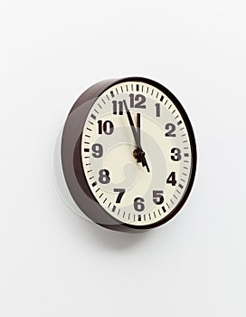 Brown clock on white office wall near noon