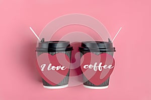 Brown coffee cups, red heart-shaped sticker on pink background.