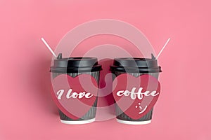 Brown coffee cups, red heart-shaped sticker on pink background.