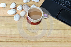 Brown coffee and labtop on wood plate