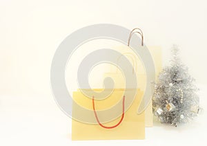 The brown color paper shopping bags and the Chrismas tree on soft white background