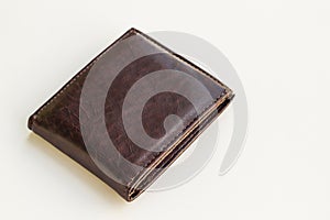 Brown colored leather wallet closed on white surface