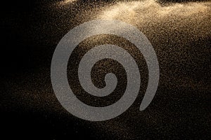 Brown colored sand splash.Dry river sand explosion isolated on black background.
