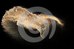 Brown colored sand splash.Dry river sand explosion isolated on black background. Abstract sand cloud