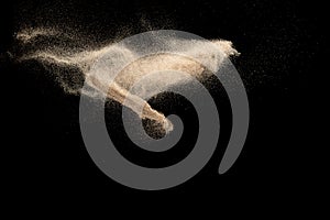 Brown colored sand splash.Dry river sand explosion isolated on black background. Abstract sand cloud
