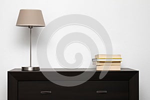 Brown commode with lamp and books in minimalism interior