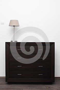 Brown commode with lamp in minimalism interior