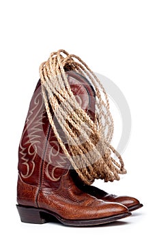 Brown cowboy boots and a coil of rope