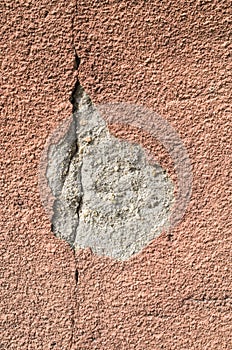 Brown crack and fallen off plaster on wall