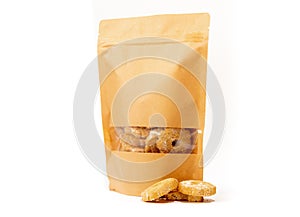 Brown craft food packaging in paper, plain doypack standup bag filled with biscuits with window and zipper on white background