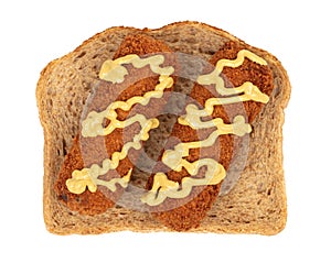 Brown crusty dutch kroket with mustard topping isolated, on a piece of bread