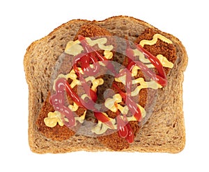 Brown crusty dutch kroket with mustard topping isolated, on a piece of bread