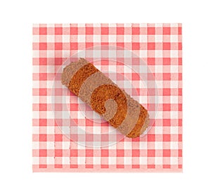 Brown crusty dutch kroket on a red napkin isolated