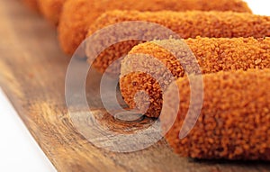 Brown crusty dutch kroketten on a serving tray, selective focus