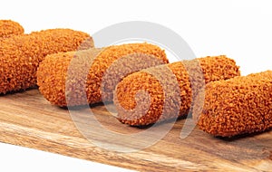 Brown crusty dutch kroketten on a serving tray, selective focus