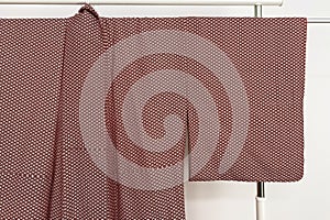 Brown curtain hanging on a clothes rack in a room, close up