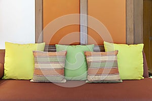 Brown cushions on a brown fabric long sofa in a modern home living room