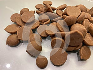 Brown delicious sweet little round chocolate callets made from Belgian milk chocolate for tempering and making homemade sweet