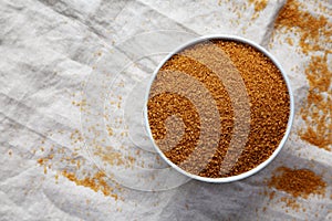 Brown Demerara Sugar in a Bowl, top view. Flat lay, overhead, from above. Copy space