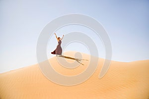 Brown dressed woman enjoys the desert dunes