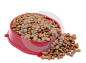 Brown dry cat or dog food in red bowl isolated on white background