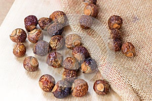 Brown dry soap nuts Soapberries, Sapindus Mukorossi for organic laundry and gentle natural skin care on light background.