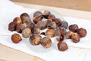 Brown dry soap nuts Soapberries, Sapindus Mukorossi for organic laundry and gentle natural skin care on light background.