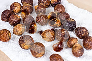 Brown dry soap nuts Soapberries, Sapindus Mukorossi for organic laundry and gentle natural skin care on light background.