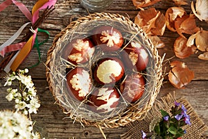 Brown Easter eggs dyed with onion peels with a pattern of leaves in a wicker basket