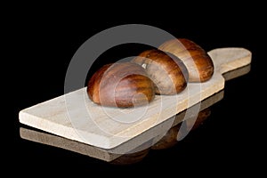 Brown edible chestnut isolated on black glass photo