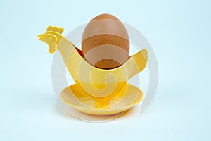 Brown egg in a hen or rooster shaped eggcup