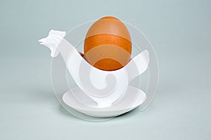 Brown egg in a hen or rooster shaped eggcup