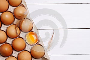 Brown eggs in carton box. Eggshell with egg yolk