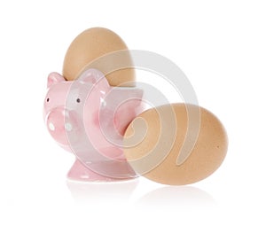Brown eggs and easter pig cup isolated on white